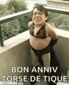 a woman in a bikini is standing on a balcony with the words `` bon anniv torse de tique '' .