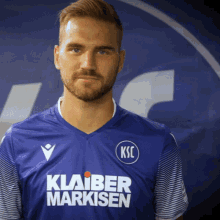a man is wearing a blue shirt that says klaber markisen
