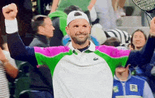 a man in a lacoste shirt is holding a tennis racquet in his hand