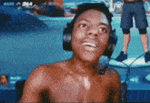 a shirtless man wearing headphones and a microphone in front of a screen that says bars on it