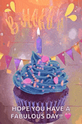 a birthday cupcake with blue frosting and a lit candle