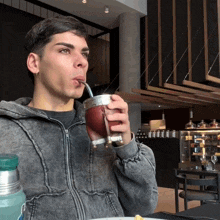 a man drinking from a cup with a straw that says ' stanley ' on it