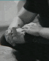 a black and white photo of a man and woman holding hands