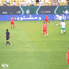 a soccer game is being played in front of a banner that says mon