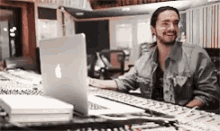 a man is sitting at a desk in front of a laptop .