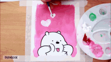 a person is painting a bear with hearts in its mouth