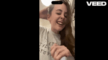 a woman wearing a t-shirt that says ' jklmnopqrstuvw ' on it is smiling