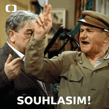 two men are standing next to each other with the words " souhlasim " on the bottom right