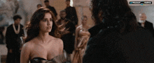 a woman in a strapless dress stands next to a man in a black jacket with the words pranay and varna on the bottom