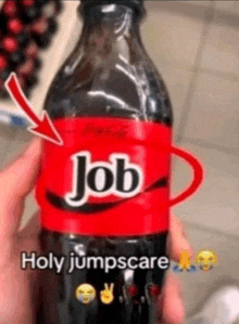 a person is holding a bottle of coke with a red label that says job on it .
