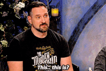 a man wearing a mighty mountain t-shirt says this this is .
