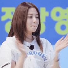 a woman wearing a white shirt that says hydrogen applauds