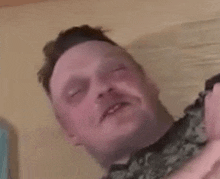 a close up of a man 's face with his eyes closed and his mouth open .