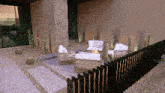 a patio with wicker furniture and cactus behind a black fence