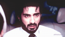 a man with a beard wearing a white shirt and tie has the name miyasaliha on the bottom