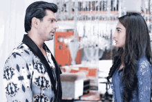 a man and a woman looking at each other in a room