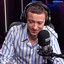 a man wearing headphones sits in front of a microphone that says bbc radio