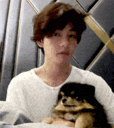a man is holding a small dog with the word redhyang written on the bottom