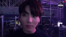 a close up of a person 's face with a big hit logo in the background