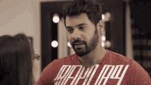 a man with a beard wears a red shirt that says " really "