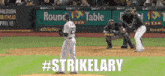 a baseball game is being played in front of a round table pizza sign