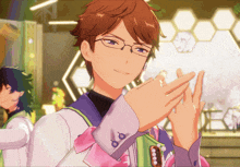 a man with glasses and a pink bow on his sleeve is clapping