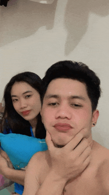 a man and a woman are posing for a picture and the man has his hand on his chin