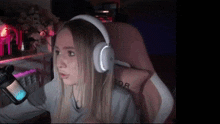 a woman is sitting in a chair wearing headphones and a microphone .