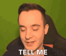 a man sitting in a chair with the words tell me written on his face