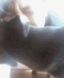 a blurred image of a person standing next to a couch .