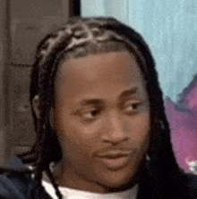 a close up of a man 's face with dreadlocks making a funny face .