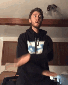 a man wearing a black hoodie with the letter s on it is dancing