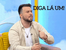 a man with a beard is sitting in front of a sign that says diga la um