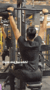 a man in a black shirt is doing pull ups in a gym with the caption gym me hu abhi