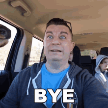 a man in a car with the word bye written on his face