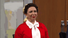 a woman wearing a red sweater and a white tie