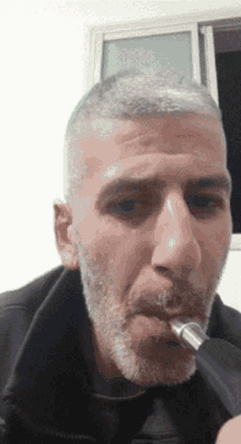 a man with gray hair and a beard is smoking a hookah