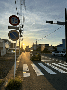 a car is driving down a road with a sign that says 30
