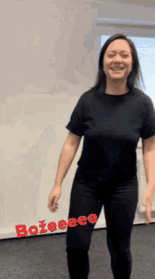a woman in a black shirt is standing in front of a white board that says bozeeee