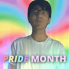 a man wearing glasses stands in front of a rainbow background with the words pride month