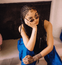 a woman wearing sunglasses has a tattoo on her wrist that says ' maybe '