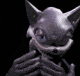 a statue of a cat is being held by a person 's hands