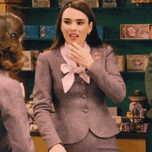 a woman in a gray suit has a brooch that says ' sally ' on it