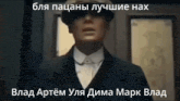 a man in a suit and hat is standing in front of a door with russian writing on it