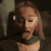 a close up of a woman sticking her tongue out while wearing a mask .