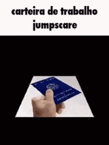 a person is holding a blue passport in their hand and it says carteira de trabalho jumpscare .