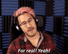 a man with pink hair is wearing headphones and saying `` for real yeah ! ''