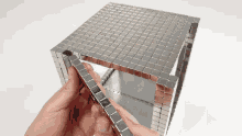 a person is holding a cube made of squares