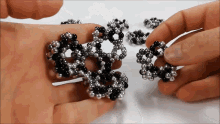 a person is holding a black and silver bracelet in their hand