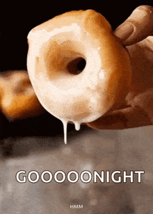 a person is holding a glazed donut with icing dripping from it and the words gooooonight written below it